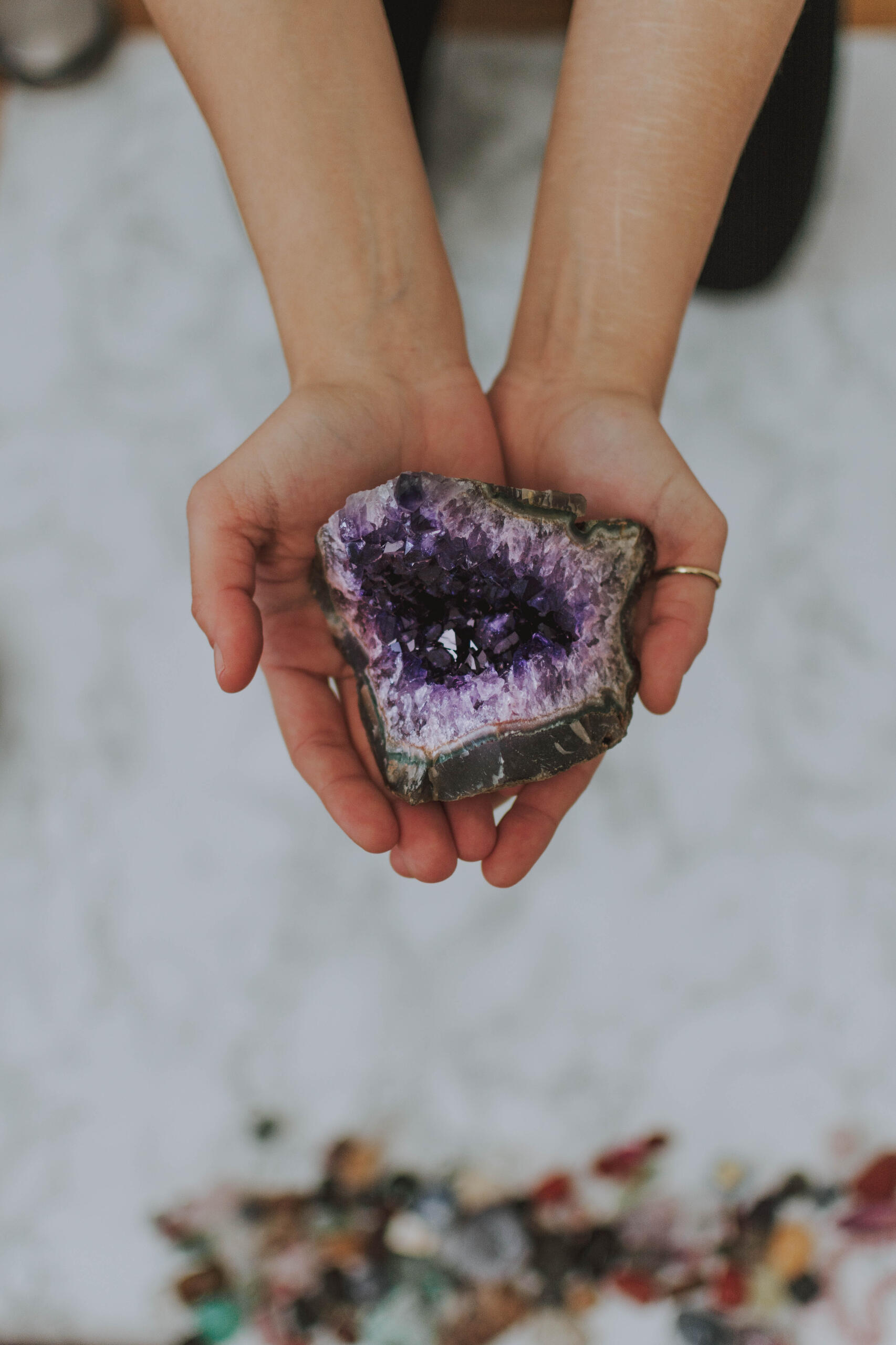 Hands holding an Amethyst crystal cluster